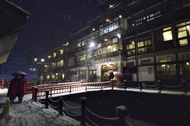冬の夜、雪化粧をした町並み【pixta】