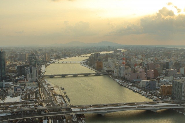 夕暮れ時の信濃川に架かる萬代橋【pixta】