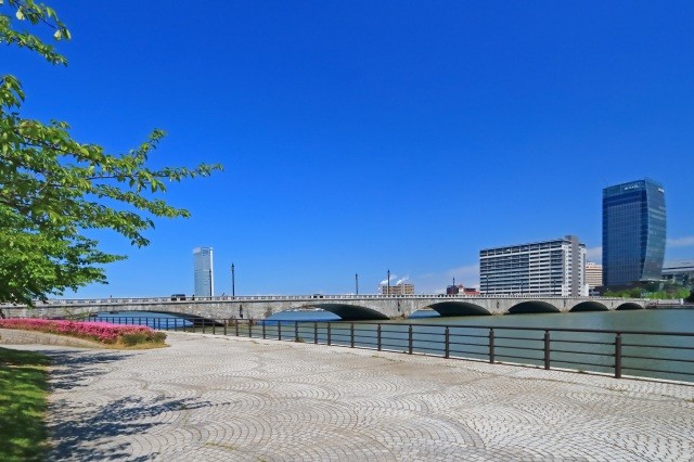 川沿いを歩きながら眺める橋【pixta】